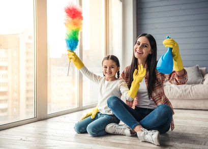 Mutter und Tochter putzen die Wohnung